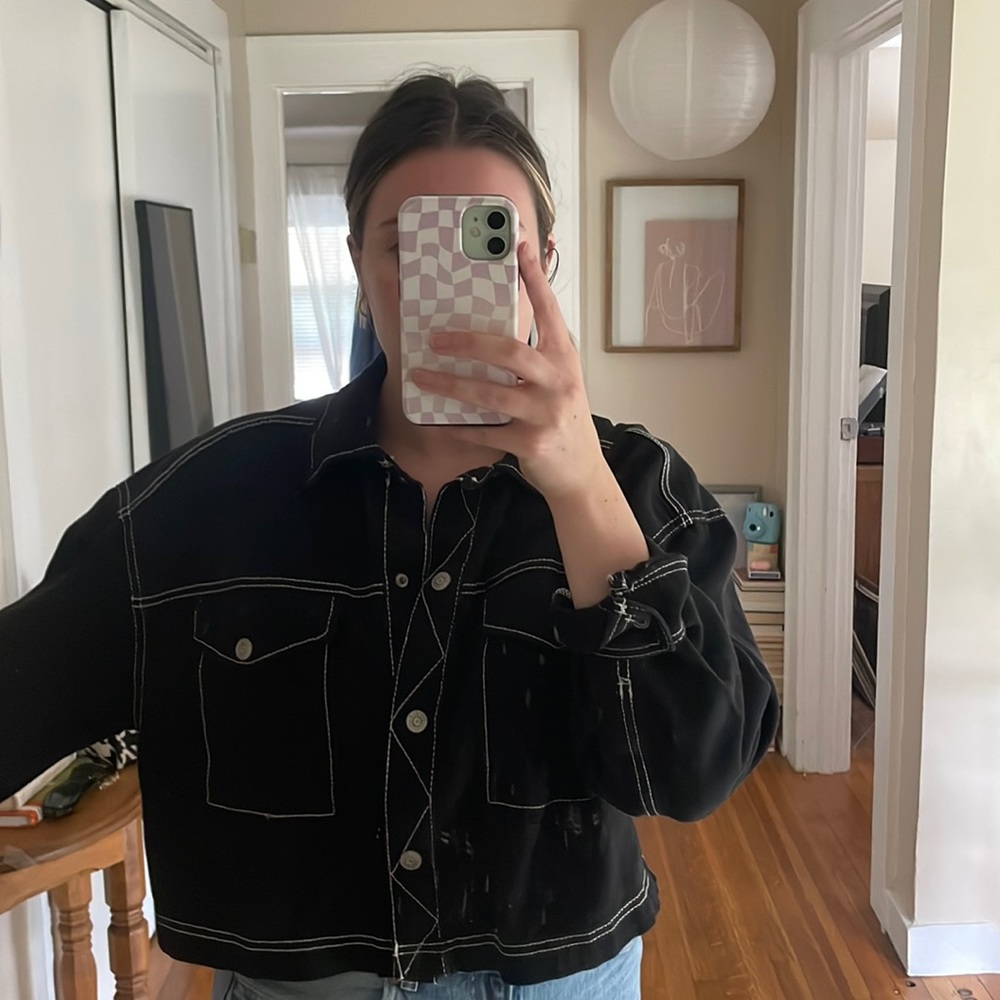 Black jacket with snap buttons. Somewhat cropped. Light weight